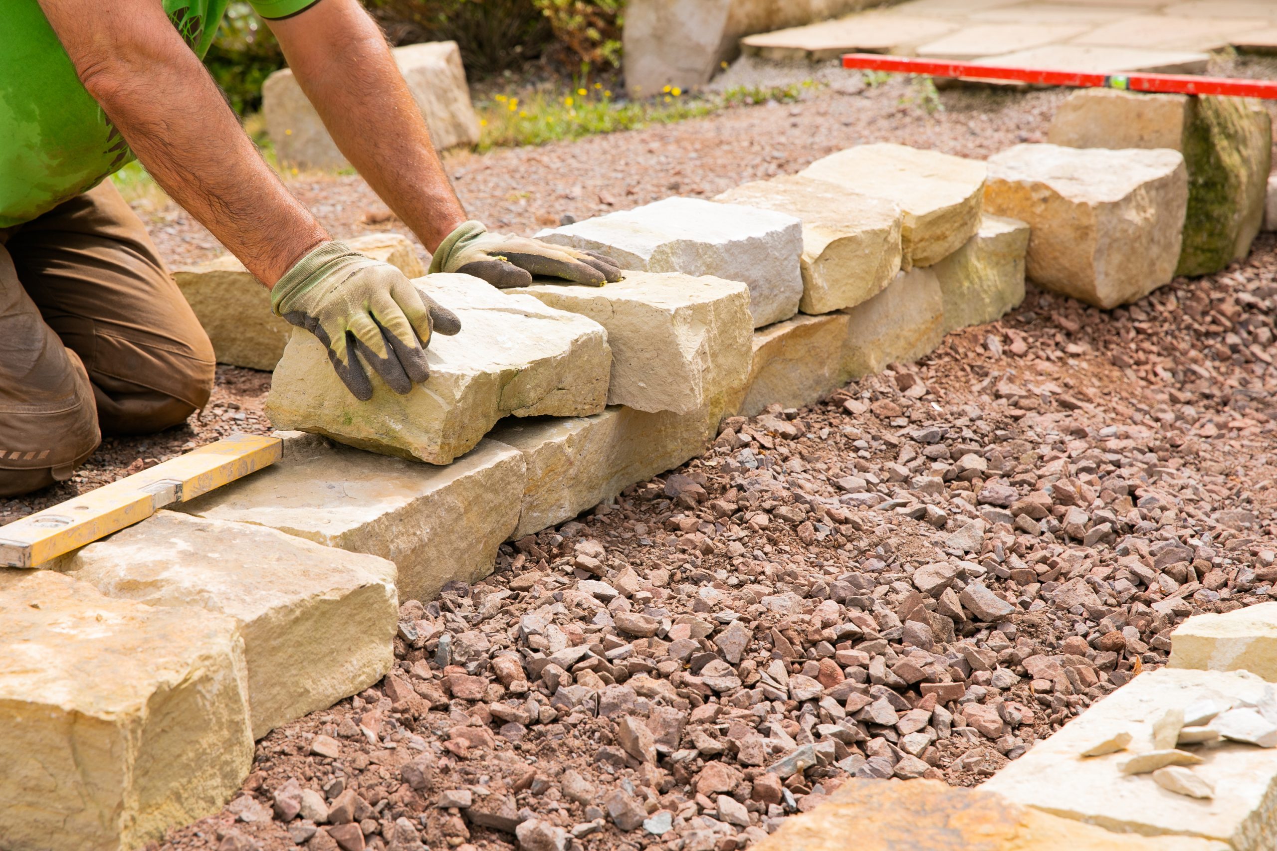Man landscaping with natural stones – Building of a dry stone w